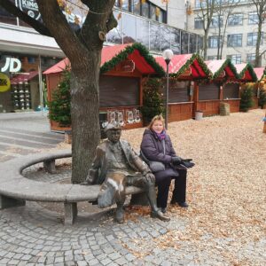 Billedet viser Jane hvile sig  på en bænk ved siden af Asmus Bremer ved et af julemarkederne.