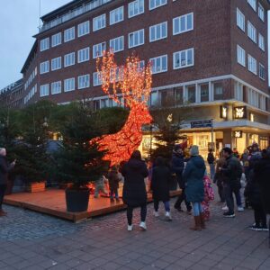 Billedet viser en skulptur af et rensdyr der er lyst op med røde lamper